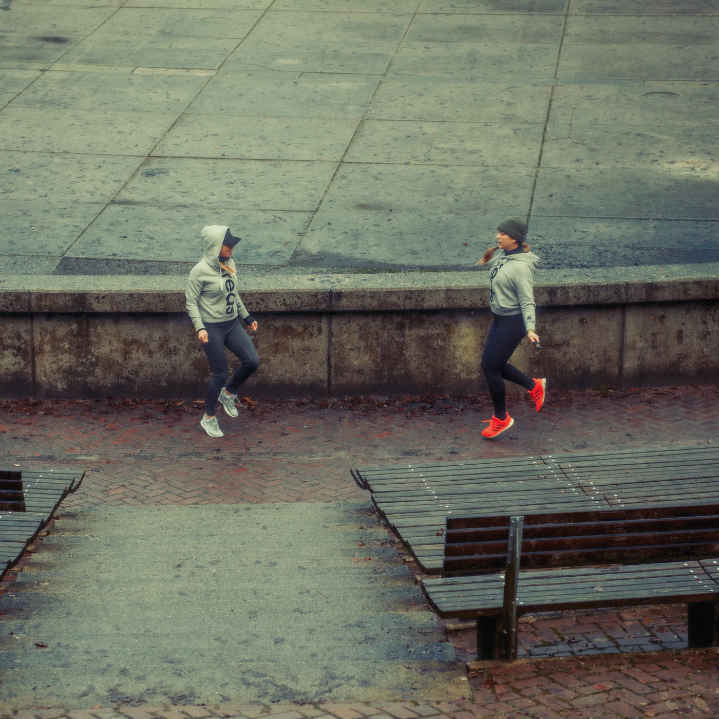 Barbara jumping rope outdoors together with a client, mid-workout
